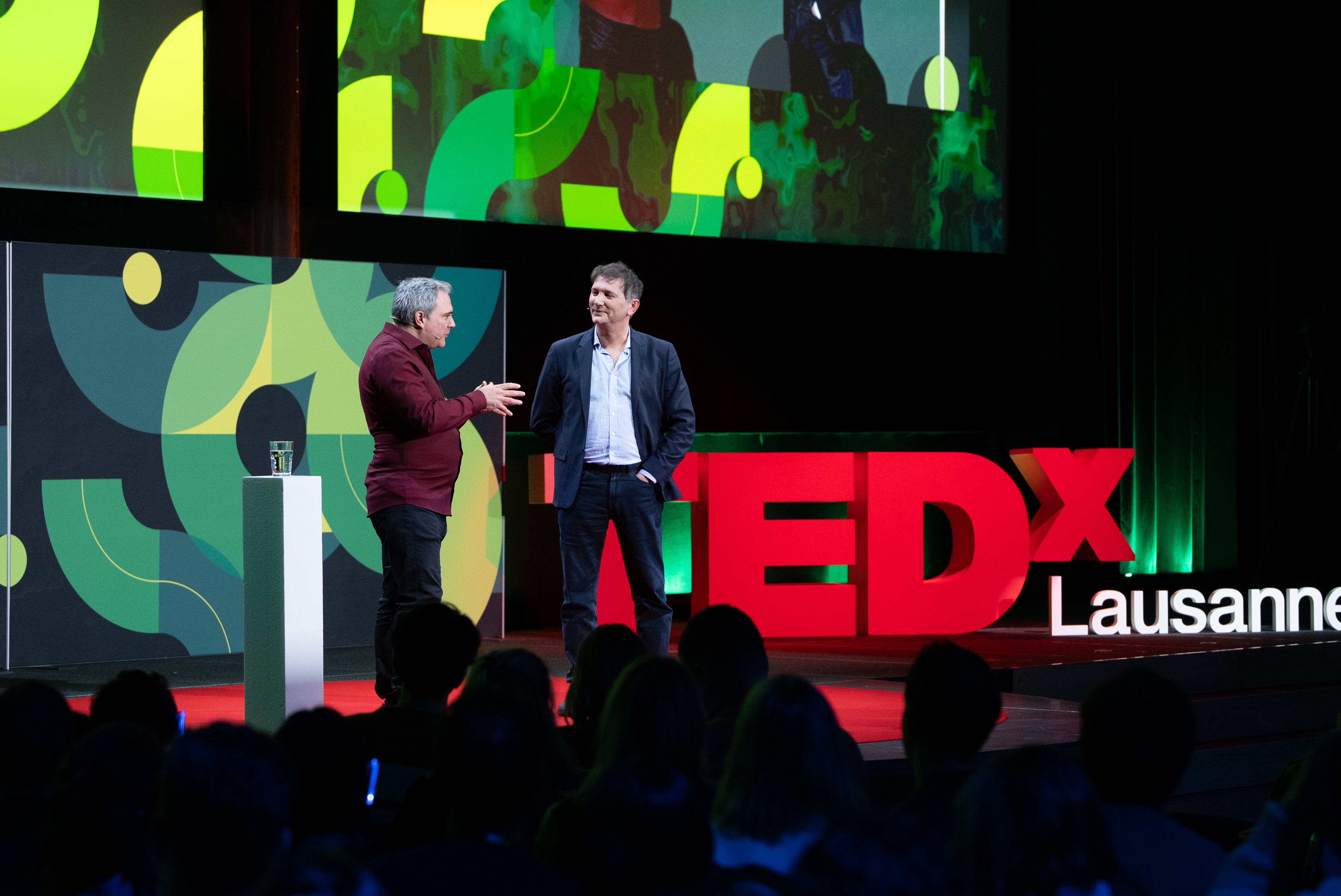Speaker presenting on stage at TEDx Lausanne 2025